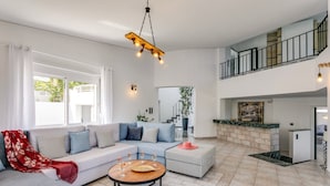 A spacious living area with a sofa set, a coffee table, and a staircase leading to an upper level. - Villa Monroe by Villa Plus (Hersonissos)