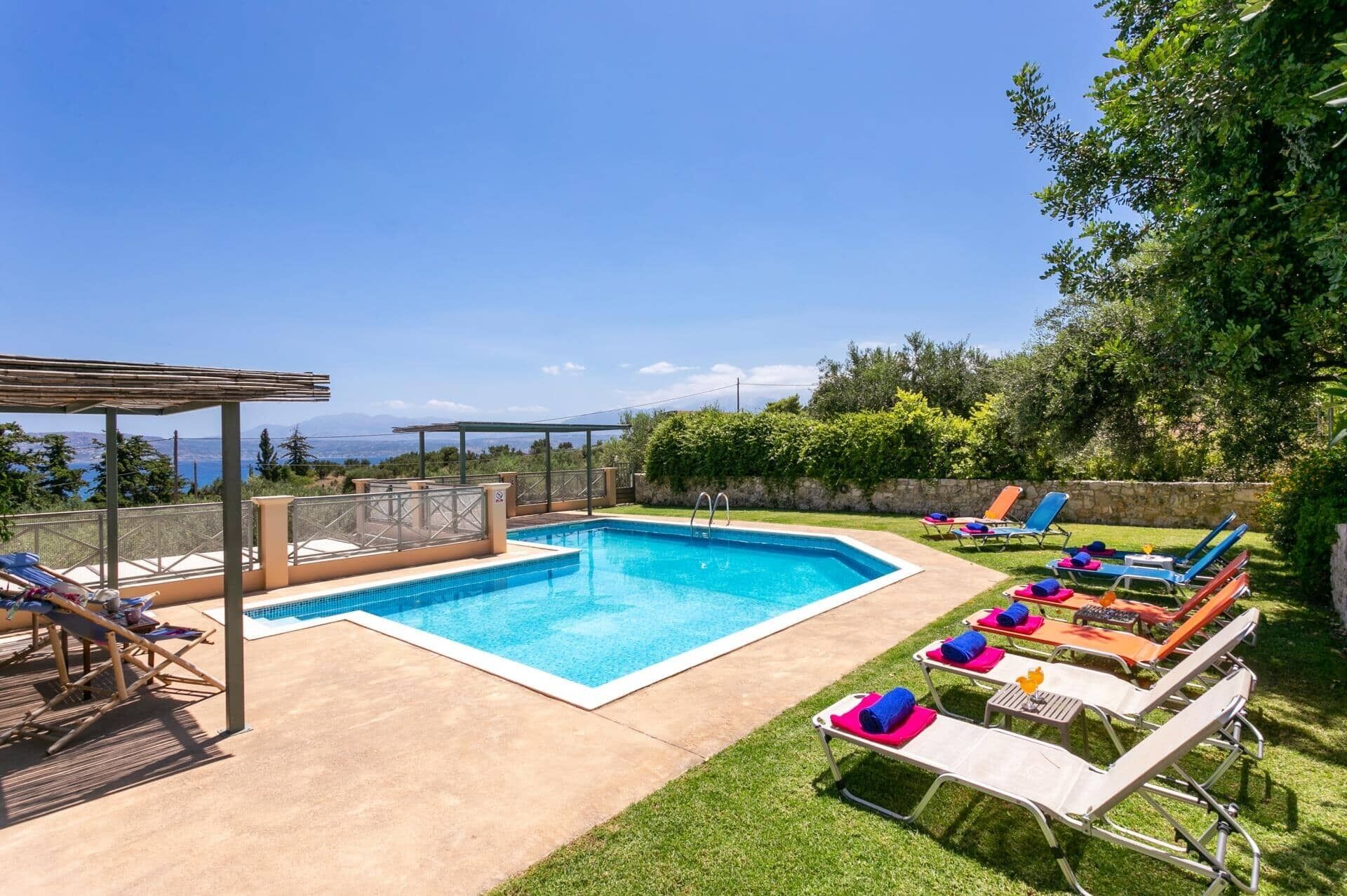 Una piscina con sillas de descanso y una pérgola, rodeada de vegetación y vistas despejadas del paisaje.