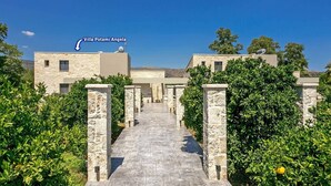 A pathway leading to Villa Potami Angela, surrounded by stone walls and lush greenery. - Villa Potami Angela by Villa Plus (Apokoronos)