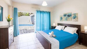 Un dormitorio con cama, mesita de noche, cómoda, ventana con cortinas y un cuadro en la pared.