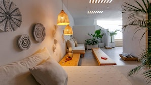 Een moderne woonkamer met een bank, een houten tafel en decoratieve muurkunst.