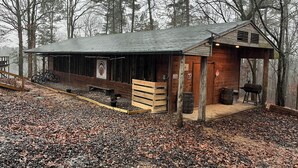 A rustic cabin with a wooden exterior, a porch, and a covered outdoor area. - Cabin 9 - Rustic Mountain Cabin Rental - Up to 3 persons (Hatfield)