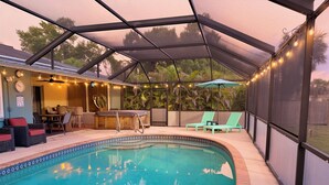 A covered outdoor swimming pool with lounge chairs, a hot tub, and string lights. - 6min to Beach. Saltwater Pool,  Fits 8ppl. (Englewood)