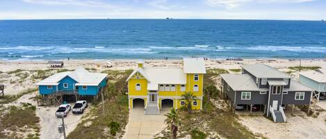 A beachfront property with multiple houses, a sandy beach, and the ocean in the background.