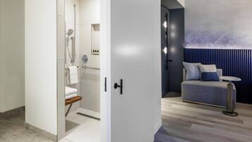 A modern bathroom with a shower, toilet, and towel rack.