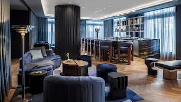 Un moderno espacio de relax con bar, asientos y un amplio ventanal.