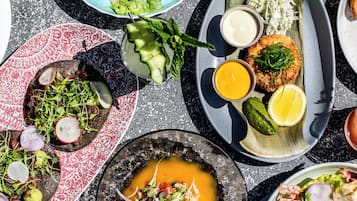 Variedad de platos en una mesa, incluyendo ensaladas, mariscos y un postre.