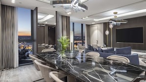 A modern dining area with a marble table, seating, and a city view. - Doubletree By Hilton Sanliurfa (Sanliurfa)