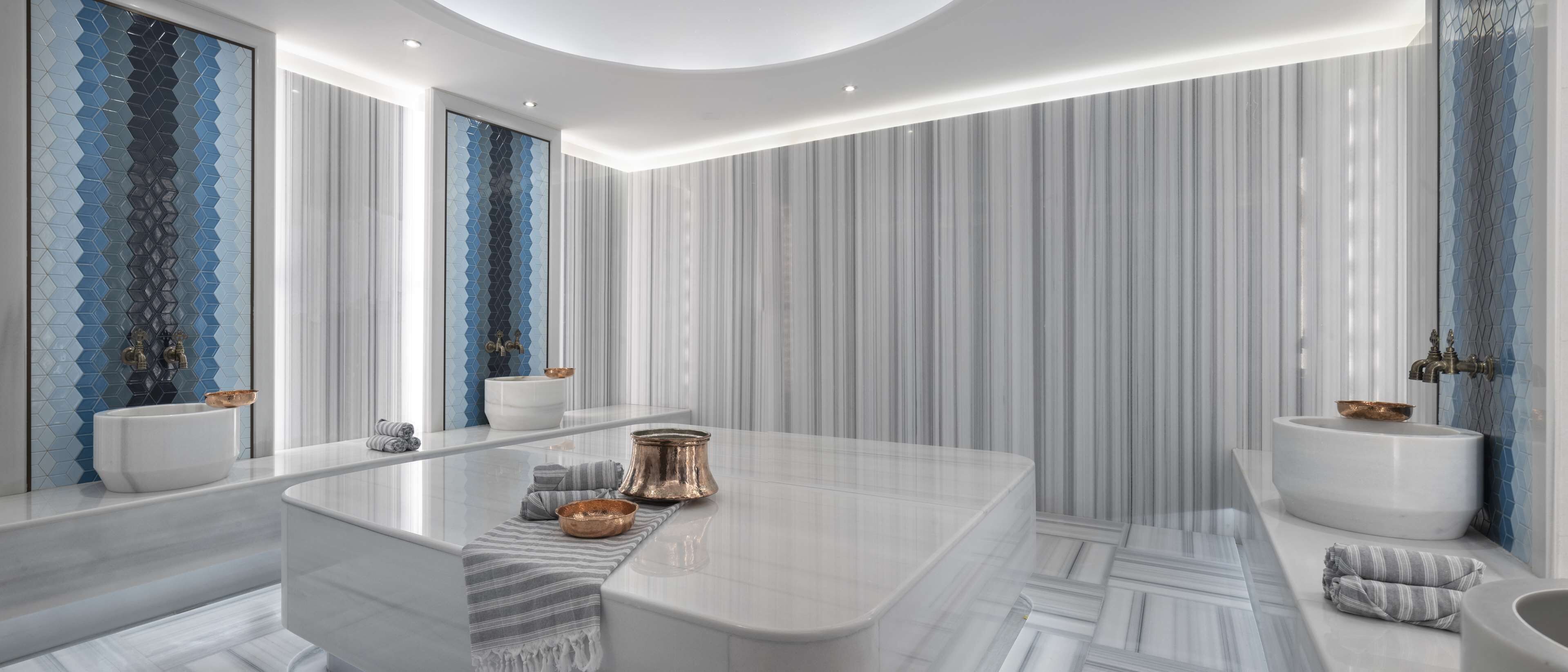A modern bathroom with a large bathtub, two sinks, and a mirror.