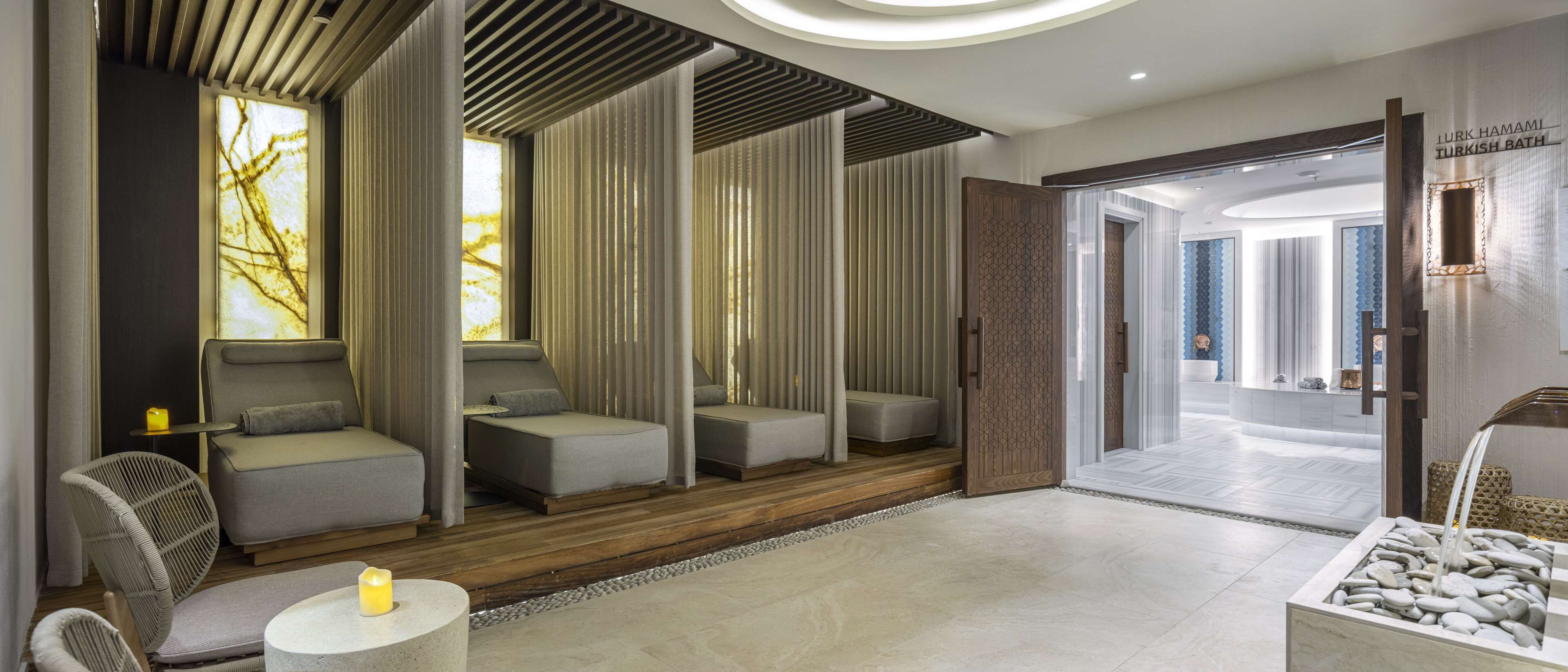 A modern spa area with seating, a reception desk, and a Turkish bath sign.