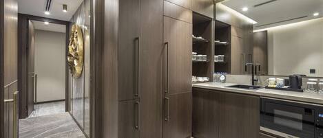 A modern kitchen with wooden cabinets, a built-in oven, and a stainless steel sink.