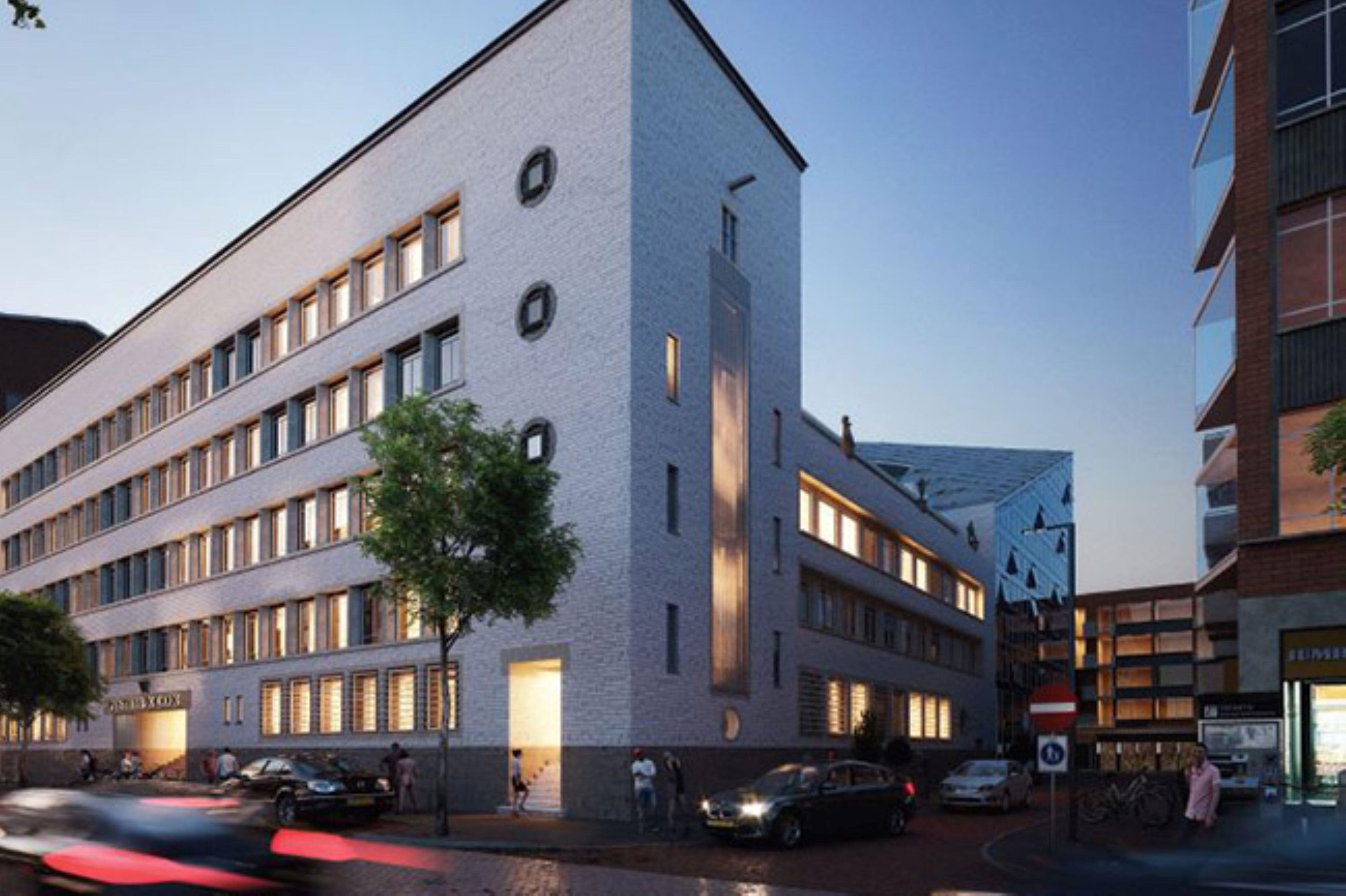 Een modern gebouw met een platte gevel, meerdere ramen en een duidelijke ingang.