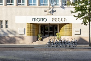 A building with a sign reading 'MOTO PESCA' and a row of bicycles parked outside. - Motto by Hilton Rotterdam City Centre (Rotterdam)