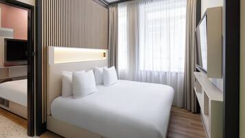 Een moderne hotelkamer met een groot bed, een televisie en een inbouwkast.