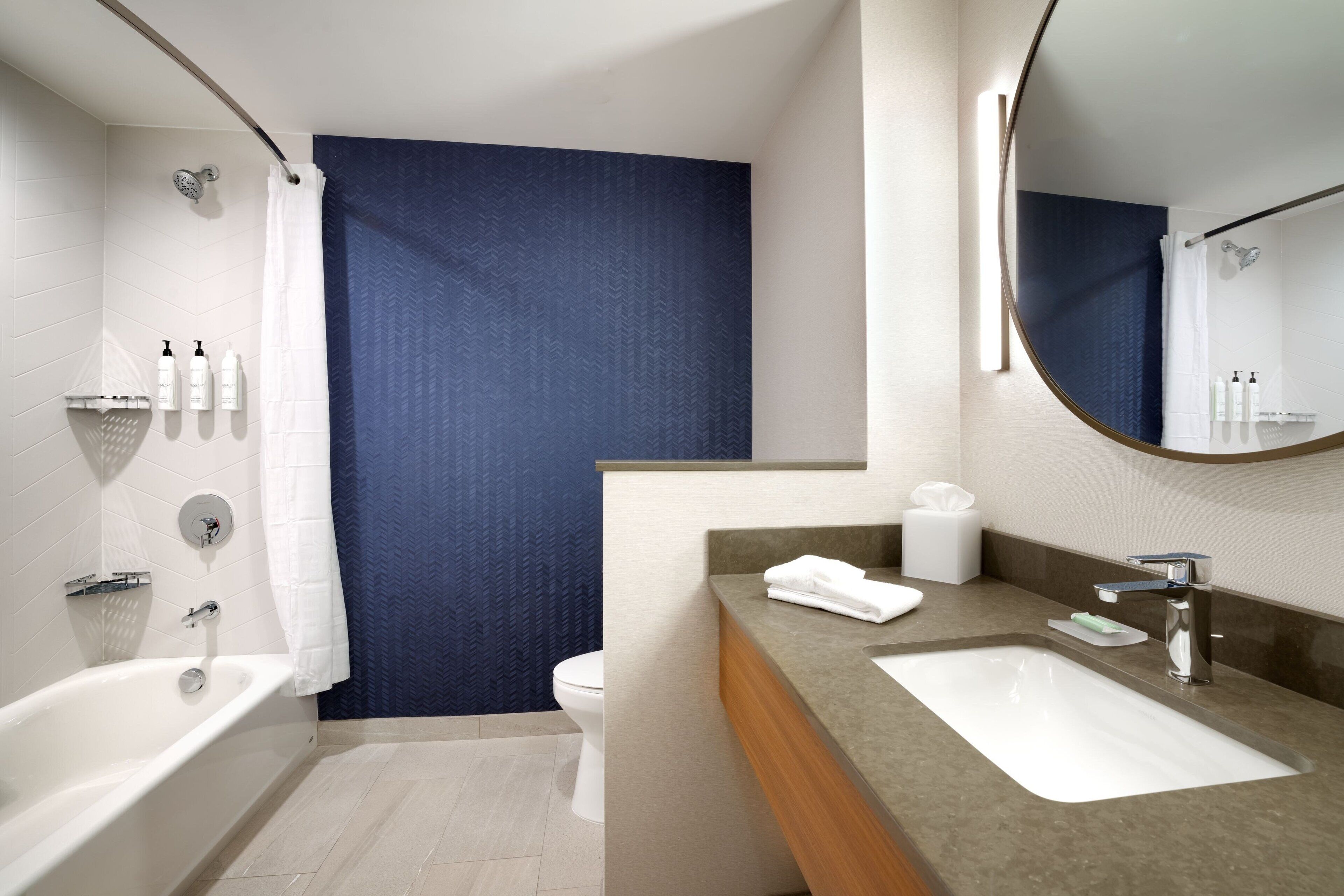 Une salle de bain moderne équipée d’une baignoire, d’un lavabo et d’un espace douche.