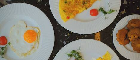 A table with various breakfast items including eggs, croissants, and a slice of toast.