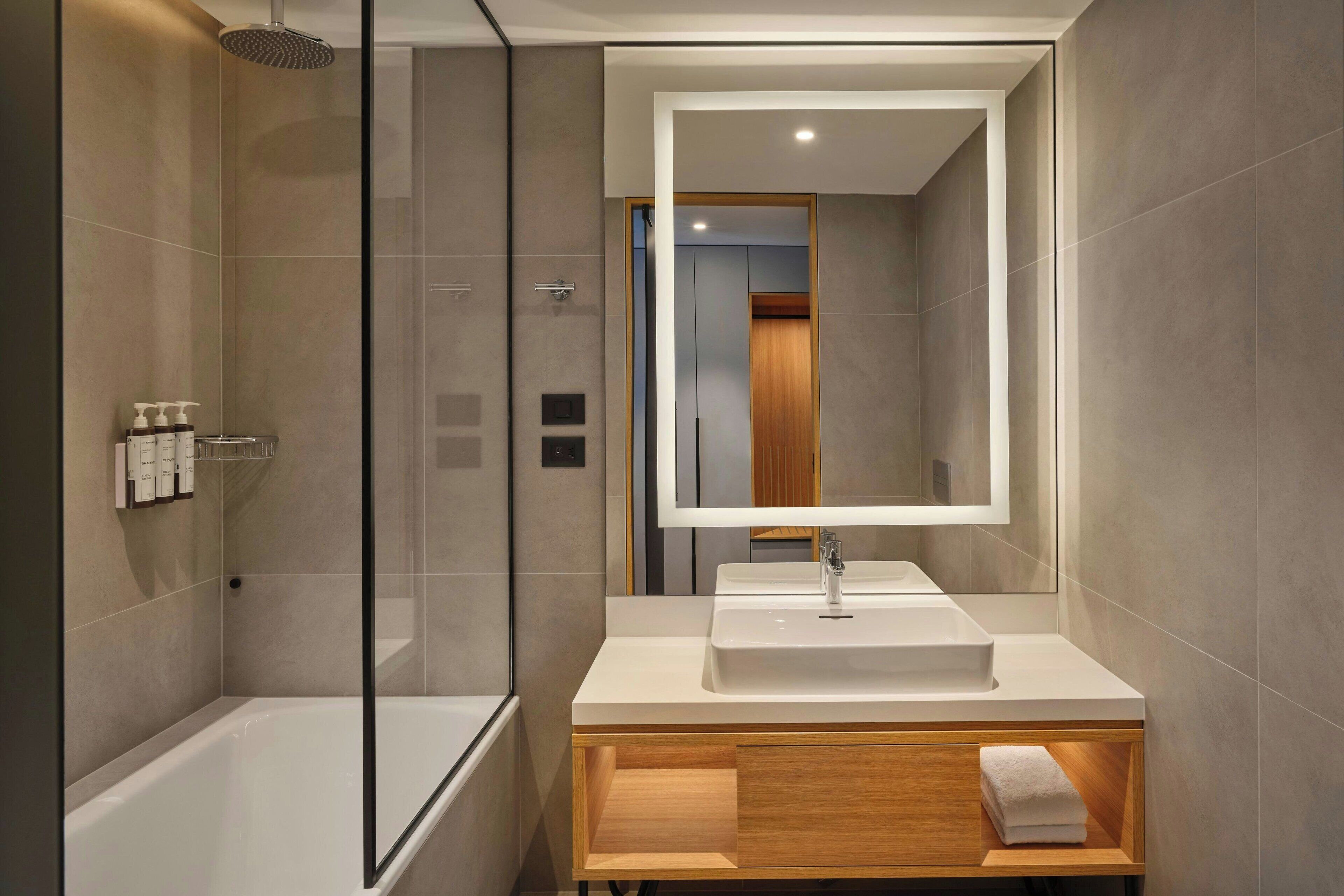 Een regendouche, designer toiletartikelen, een haardroger, badjassen