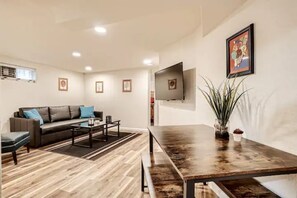 Una sala de estar moderna con un sofá, una mesa de centro y un televisor montado en la pared.