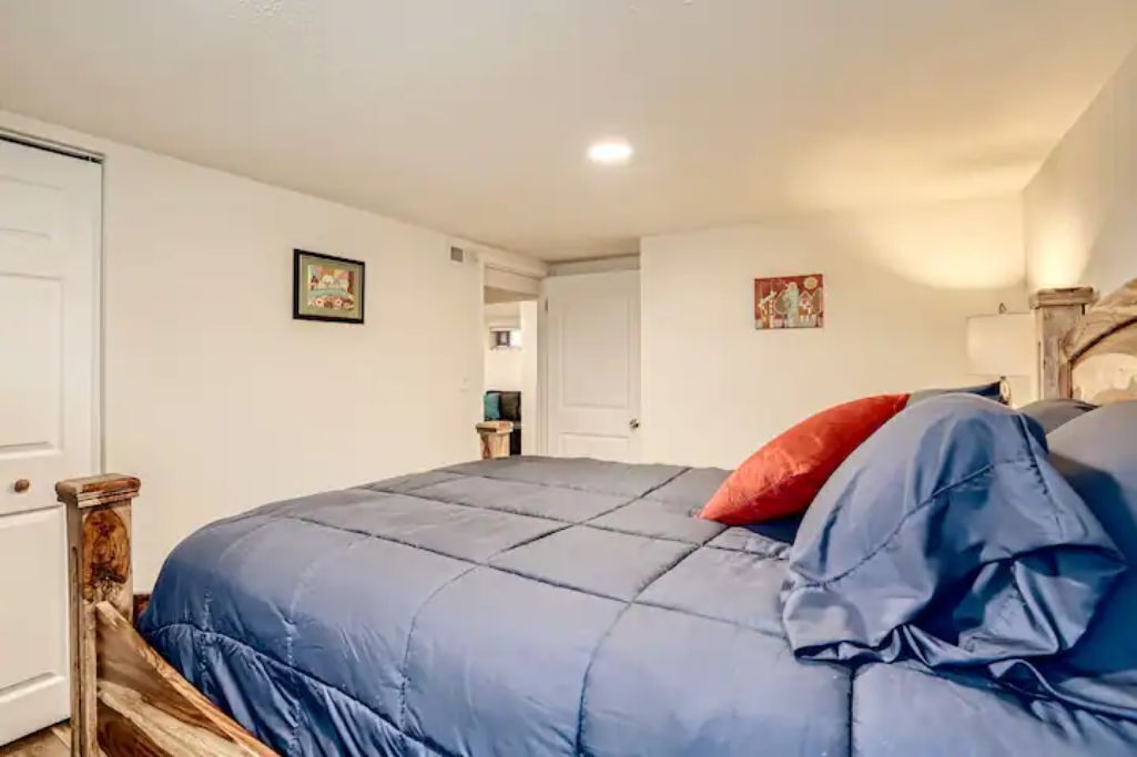 Ein Schlafzimmer mit einem großen Bett, einem Holzkopfende und einer weißen Tür.