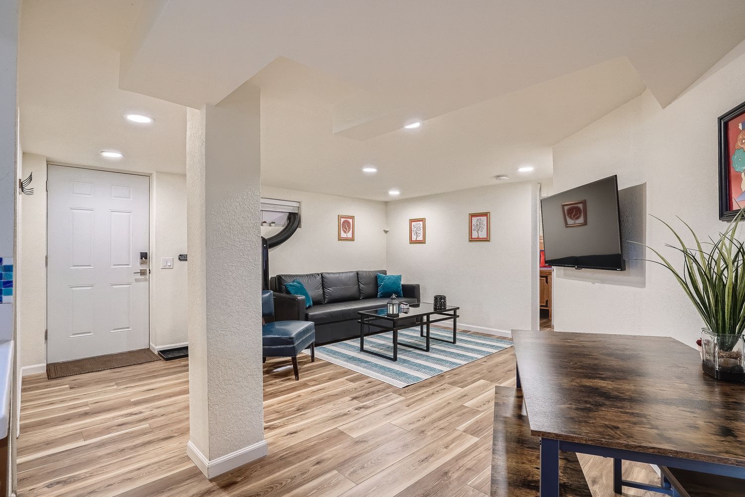 A modern living room with a sofa, coffee table, and a TV mounted on the wall.
