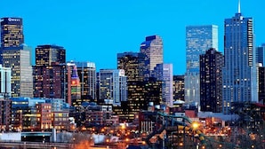 A city skyline with multiple high-rise buildings, including a prominent tower with a spire. - Sloans Lake Getaway Near Broncos & Downtown Denver (Lakewood)
