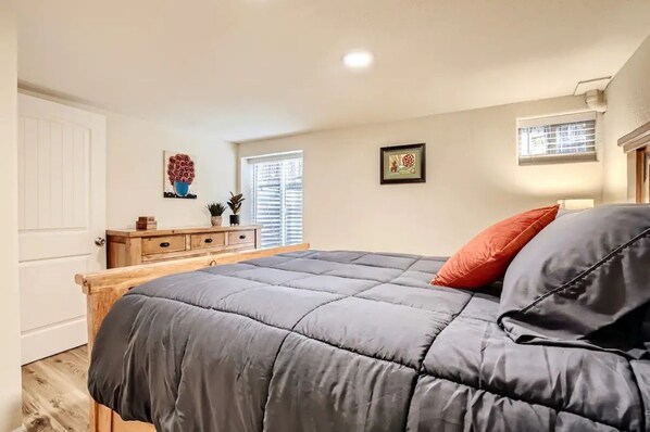 Une chambre à coucher avec un lit, une commode et des œuvres d’art accrochées aux murs.