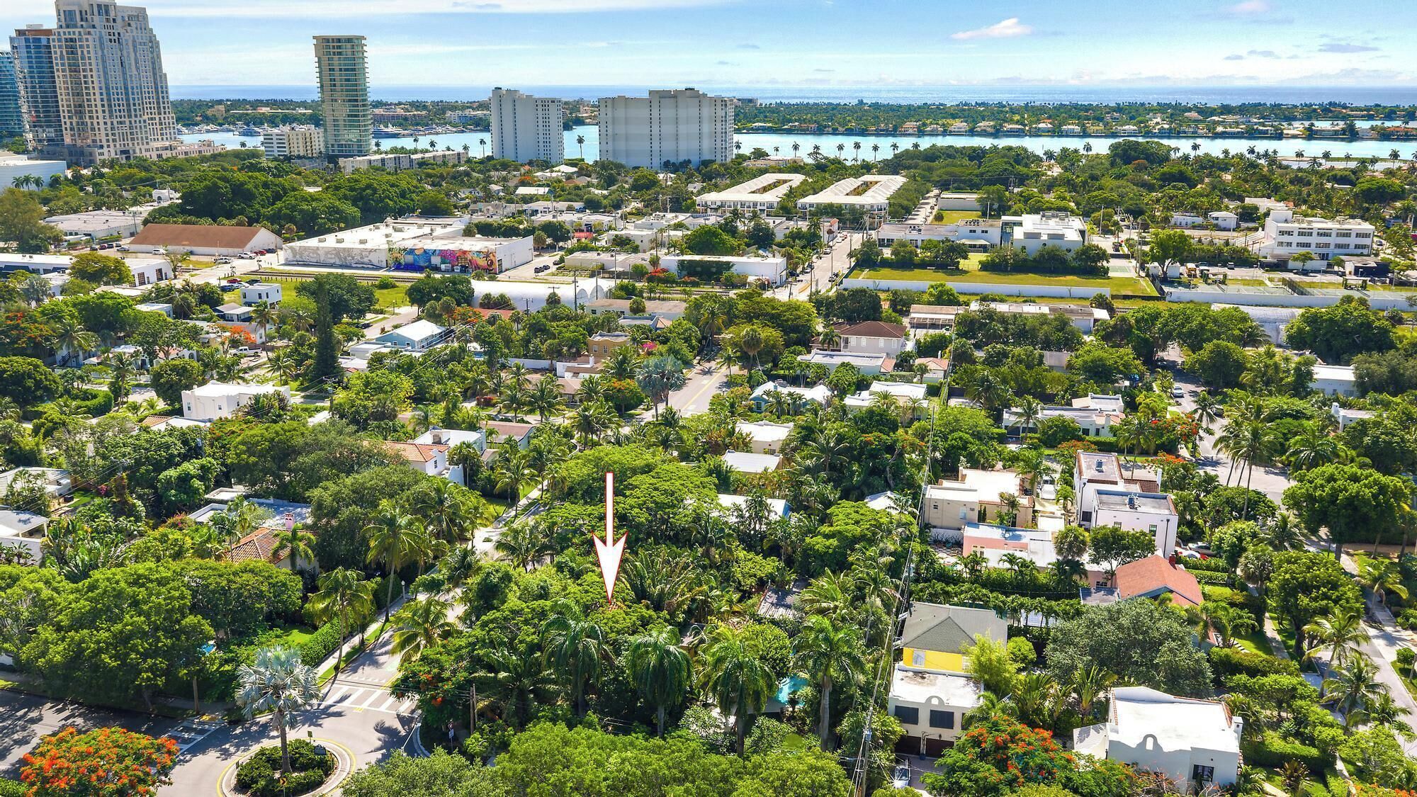 A residential area with houses, roads, and a distant view of a marina.