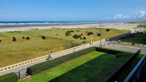 A coastal view with a beach, grassy areas, and a paved walkway. - Sand Dollar Haven at Seaside Beach Club Unit 306 (Seaside)