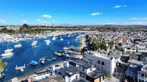 A marina with numerous boats docked, surrounded by residential buildings and a clear blue sky. - Classic Balboa Cottage, Newly Updated with A/C! (Newport Beach)