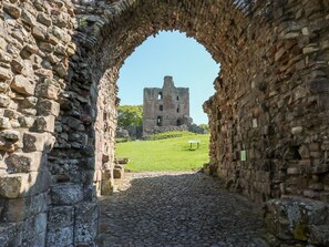 An arched stone corridor leading to a historic castle ruin. - 46 Castle Street (Berwick-upon-Tweed)
