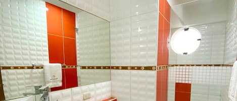 Un baño moderno con lavamanos blanco, inodoro y zona de ducha.