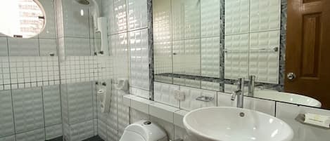 Een moderne badkamer met toilet, hygiëneschuimer en wastafel.