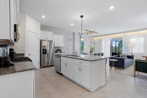 Enjoy meals and socializing in this well-lit kitchen with a central island, refrigerator, and dishwasher.