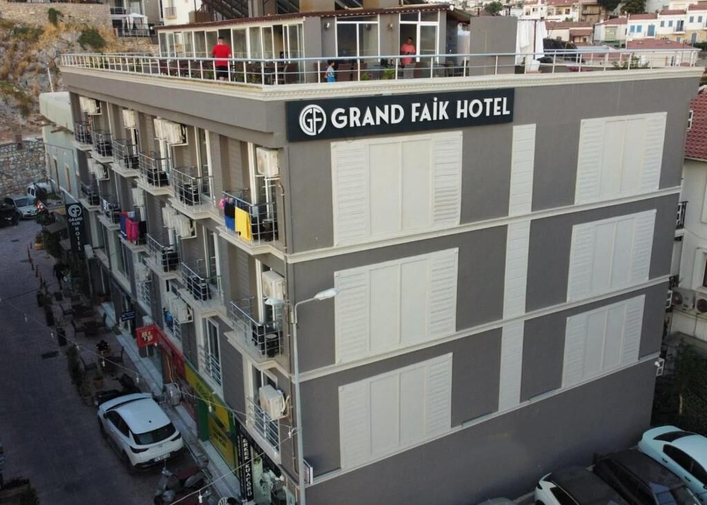 Ein mehrstöckiges Hotel mit Balkonen und einer Dachterrasse.