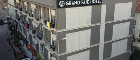 Ein mehrstöckiges Hotel mit Balkonen und einer Dachterrasse.