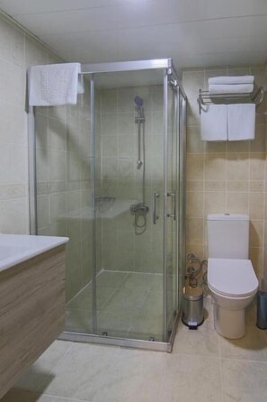 Standard Double or Twin Room | Badkamer | Een douche, pantoffels, handdoeken