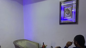 A room with a sofa, a coffee table, and a framed artwork on the wall. - Novatel Hotel (Lekki)