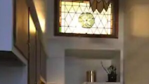 A compact kitchen with a gas stove, a refrigerator, and a window with a geometric pattern. - Creative living 7 (Youngstown)
