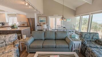 A spacious living area with a gray sofa, a coffee table, and a view of the outdoors.
