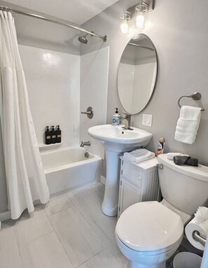 Un baño moderno con bañera, lavabo, inodoro y ducha.