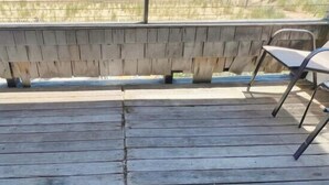 Une terrasse en bois avec un paillasson sur lequel on peut lire « Naut's Retreat » et « Feel Like ».