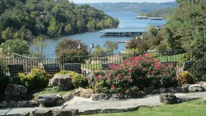 Vista a un lago con un muelle, un sendero de piedra y una zona de estar.