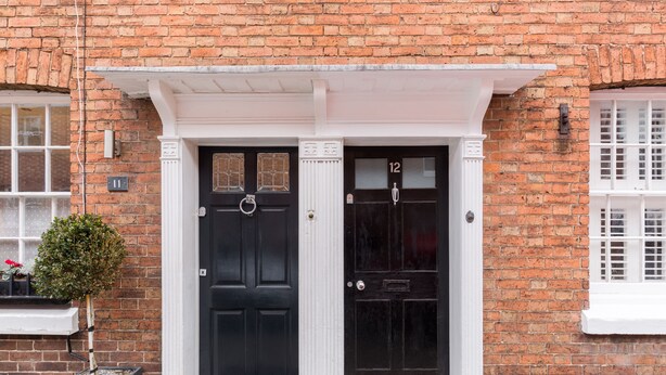 A brick building with two black doors, numbered 11 and 12, and a small potted plant beside door 11. - Shakespeare House, Free Parking, Town Centre Location (Stratford-upon-Avon)