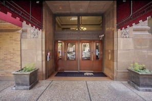 Stunning hotel entrance with a symmetrical facade, featuring large glass doors and stone pillars.