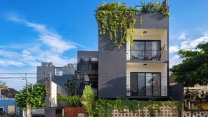 A modern two-story building with a balcony, a gate, and a fence. - UJO Tulum (Tulum)
