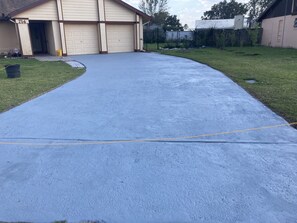 driveway leads to a home with a garage marked 714, set amidst a well-manicured lawn and a wooden fence.