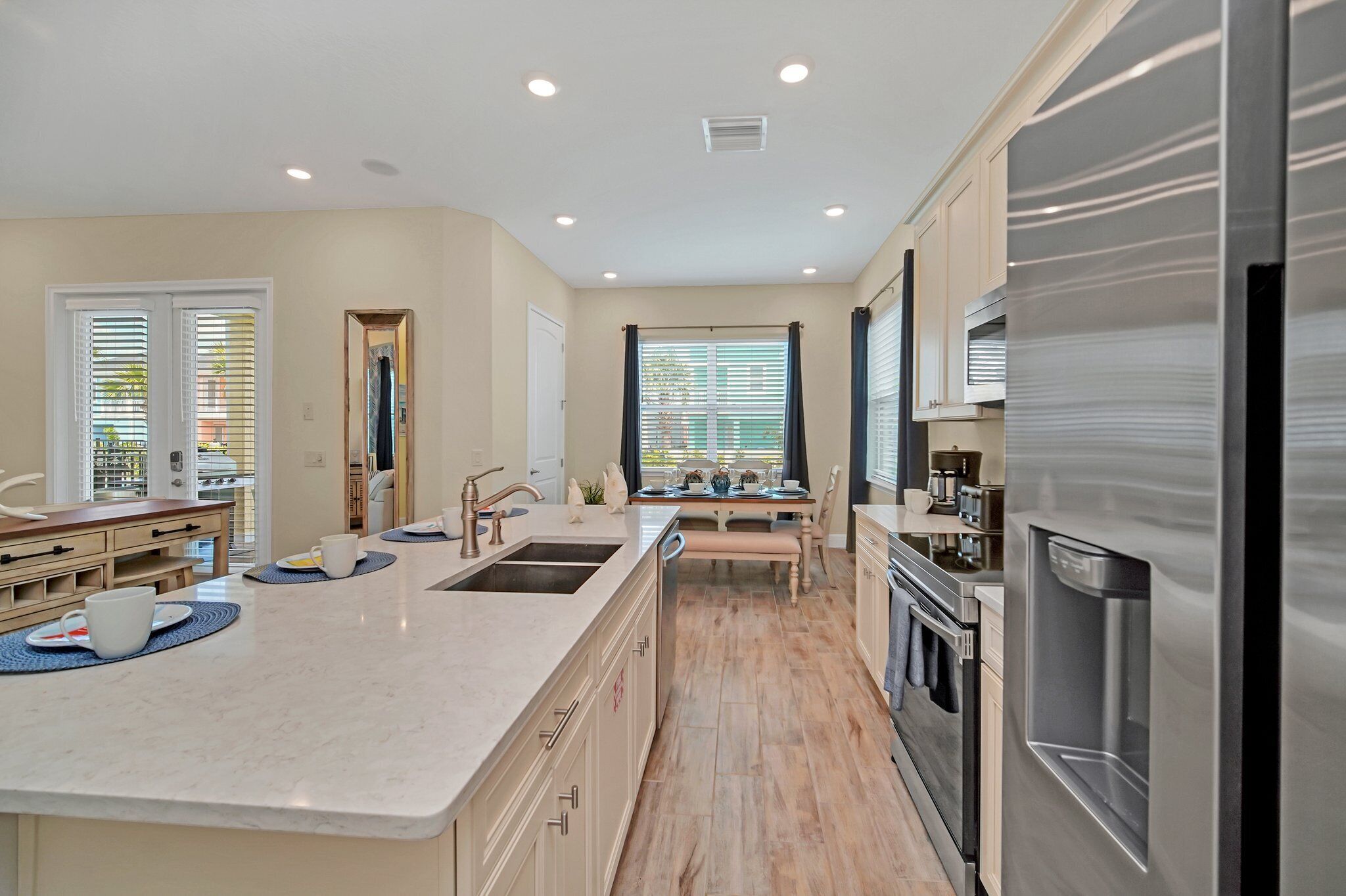 A modern kitchen with a central island, stainless steel appliances, and a view of the dining area.