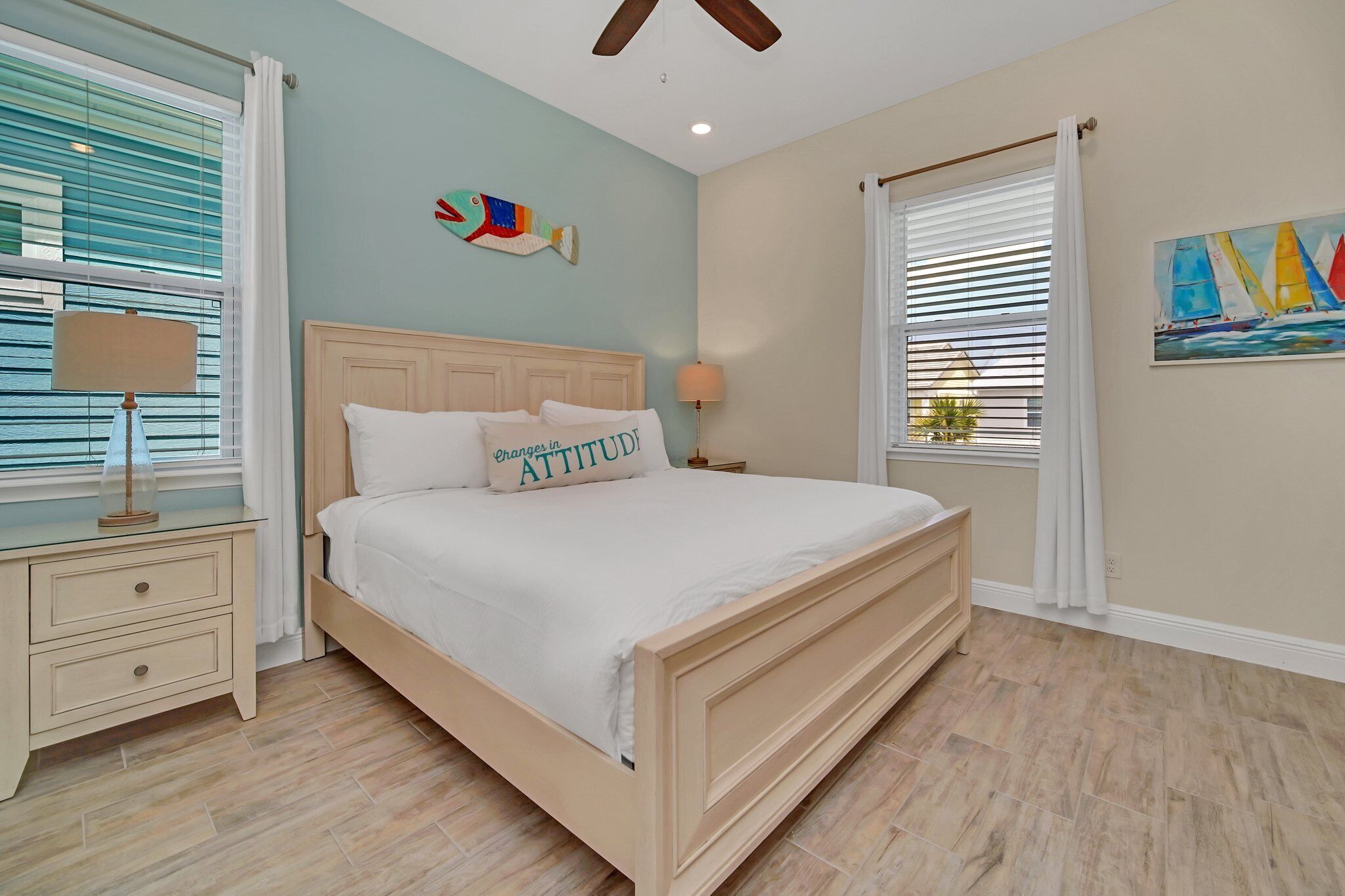 A bedroom with a bed, nightstands, and a ceiling fan.