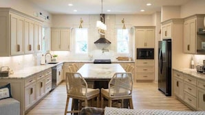 A spacious kitchen with a large island, white cabinetry, and modern appliances. - Lakefront-Lakeview-Steps to the Water-Tim's Ford Lake LUXURY Home & DOCK (Winchester)