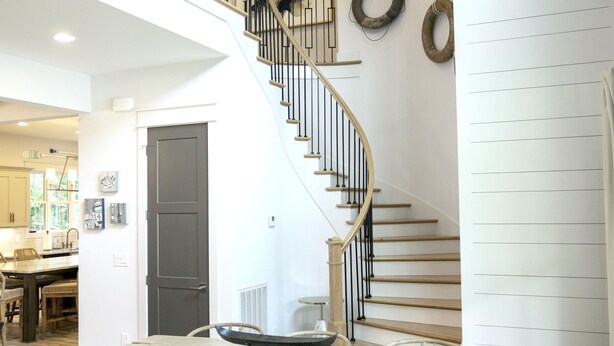 A spacious living area with a wooden dining table, chairs, and a staircase with a railing. - Lakefront-Lakeview-Steps to the Water-Tim's Ford Lake LUXURY Home & DOCK (Winchester)